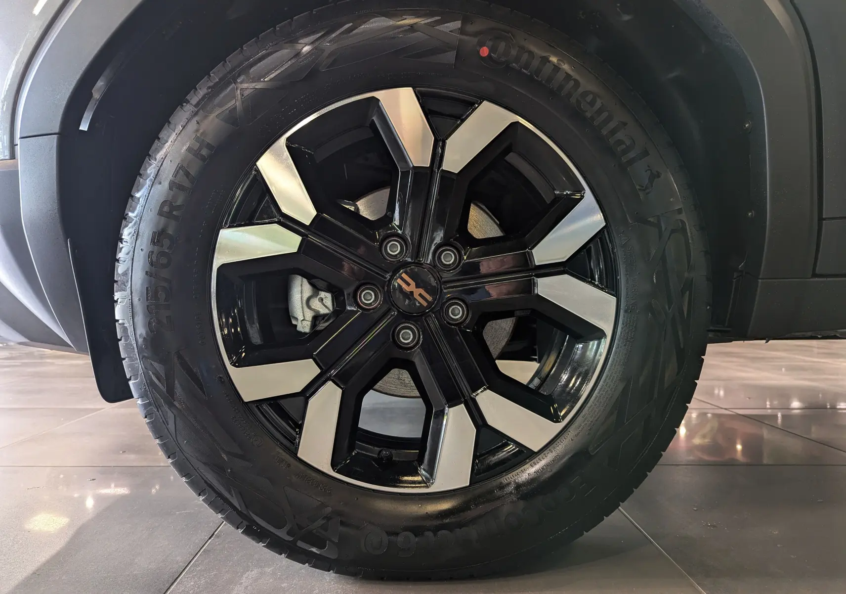 Gros plan sur la roue avant droite du Dacia Duster 2025 gris schiste avec jante alliage noire et argentée.