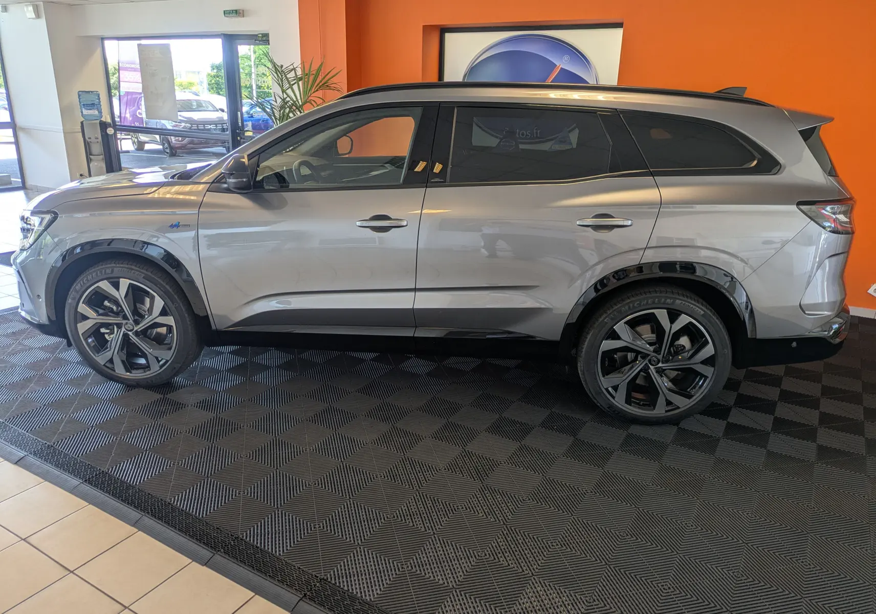 Profil côté gauche du Renault Espace VI E-Tech Full Hybrid 200 gris schiste avec jantes alliage 20 pouces Daytona et barres de toit noires.