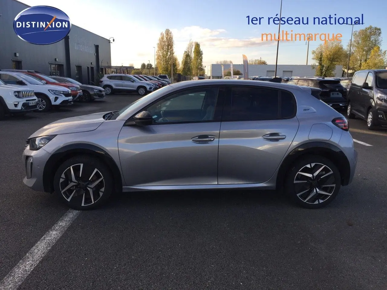Peugeot 208 gris Artense métal vue de profil côté gauche, avec jantes noires et badge GT sur l'aile arrière.