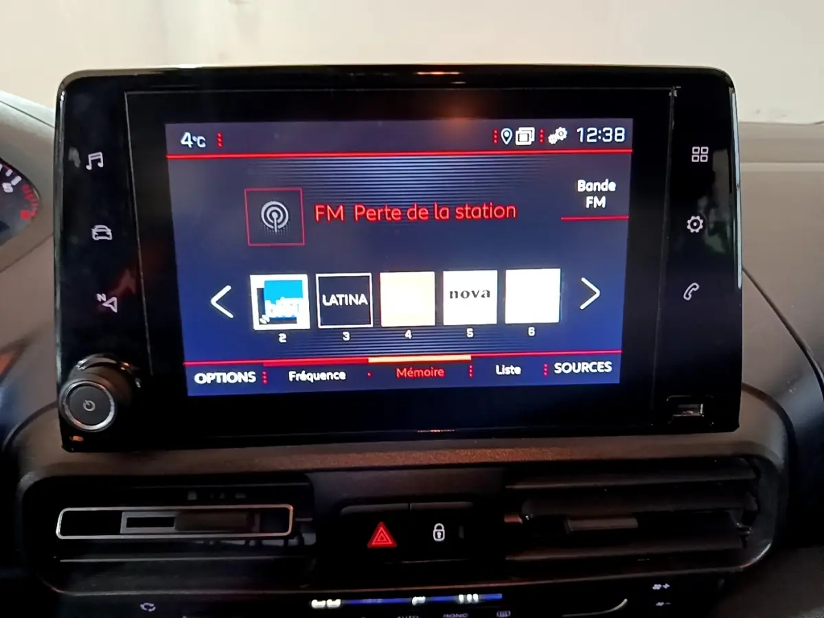 Écran tactile central du tableau de bord du Peugeot Rifter marron, affichant les stations radio FM.