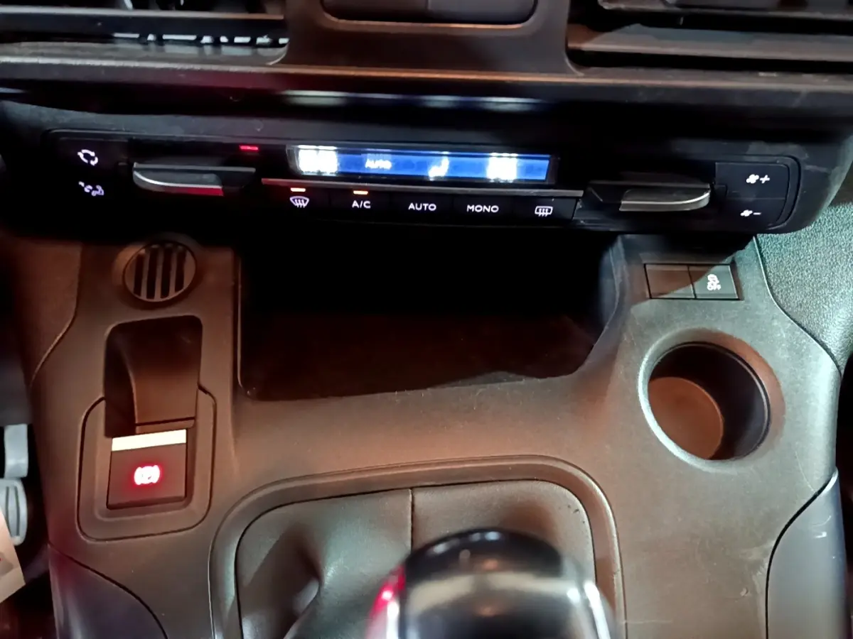 Détail de la console centrale noire du Peugeot Rifter BlueHDi 100 Allure 2019 avec frein à main électrique et commandes climatisation.
