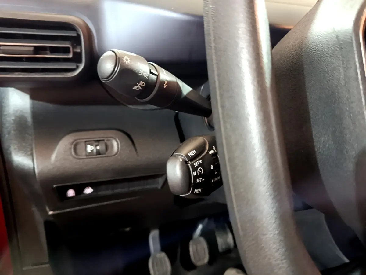 Gros plan sur les commandes de régulateur et éclairage derrière le volant du Peugeot Rifter BlueHDi 100 Allure 2019.