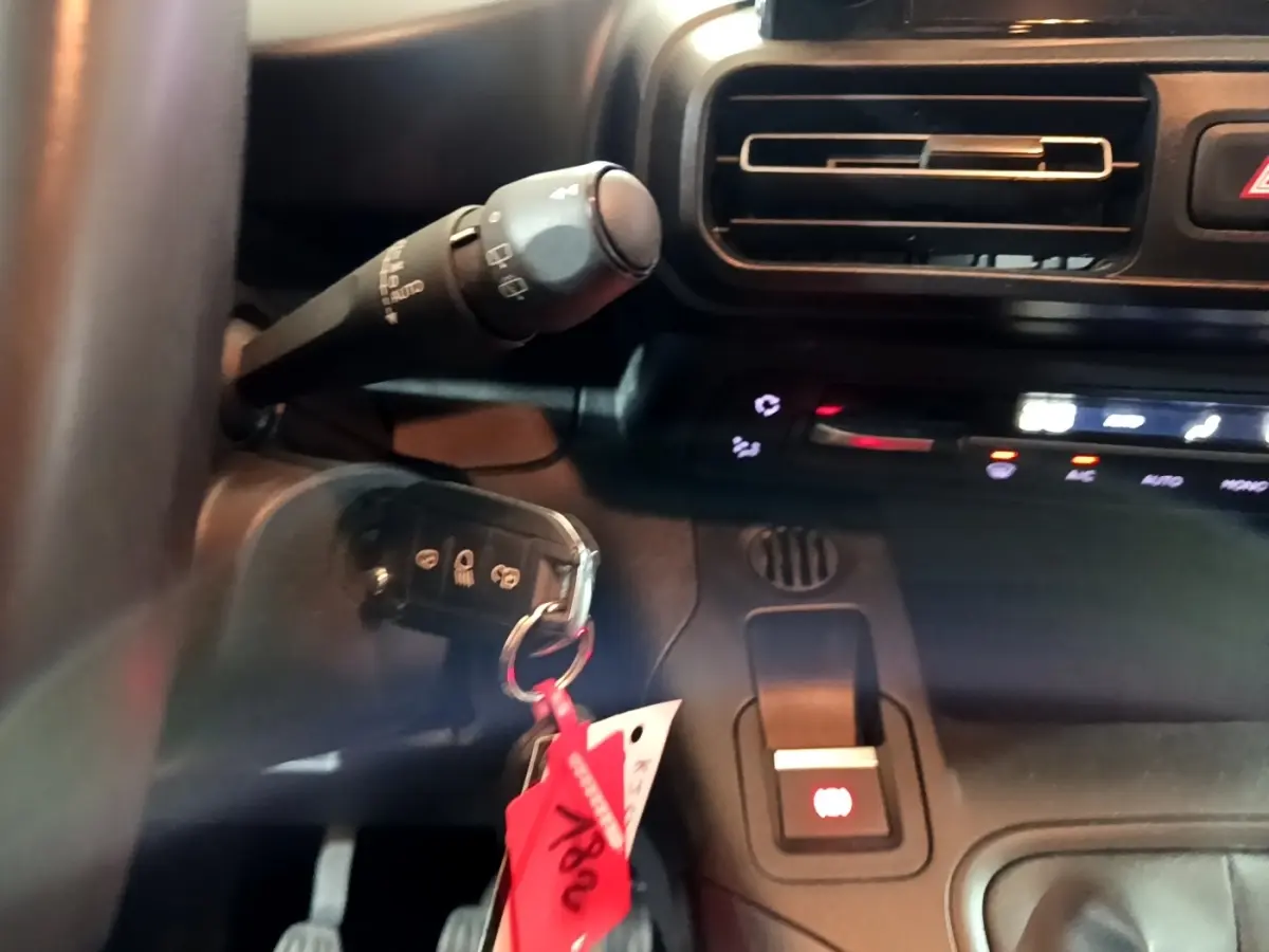 Gros plan sur la commande de frein à main électrique et clé de contact dans l'habitacle noir du Peugeot Rifter Marron 2019