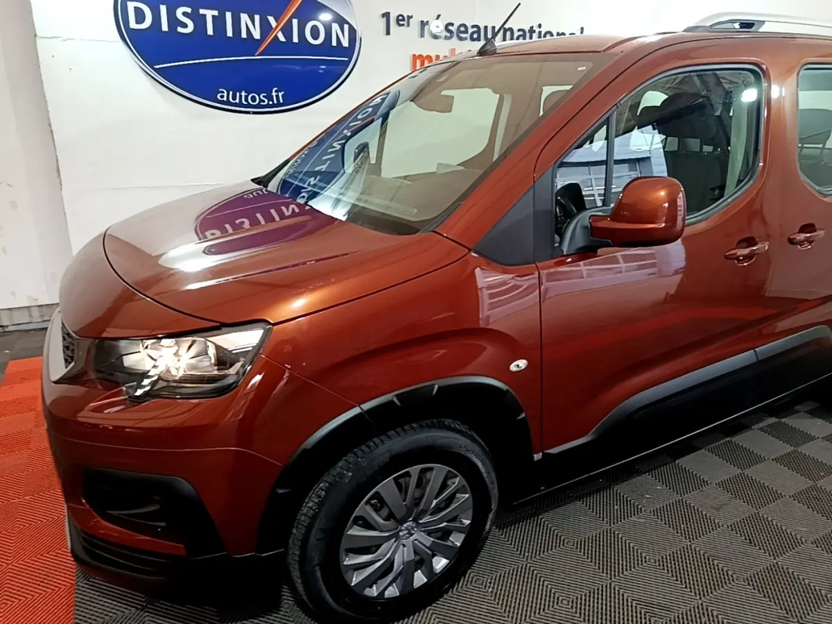 Vue 3/4 avant droit du Peugeot Rifter BlueHDi 100 Allure marron, avec jantes alliage et rétroviseurs assortis.
