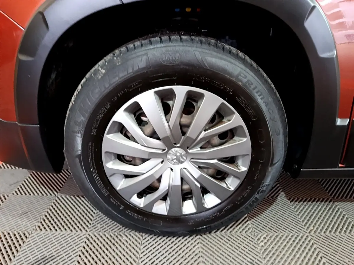 Gros plan sur la roue avant gauche du Peugeot Rifter marron, mettant en valeur la jante argentée et le pneu Michelin.