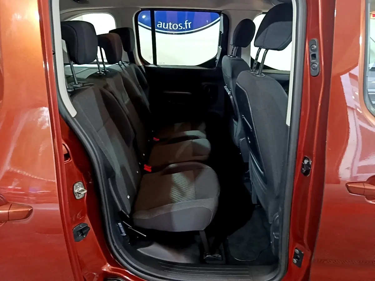 Vue intérieure sur la banquette arrière noire du Peugeot Rifter marron 2019, porte latérale ouverte côté droit.