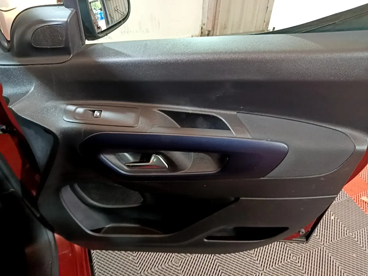 Gros plan sur la porte intérieure côté gauche du Peugeot Rifter 2019, avec poignée noire et bouton de vitre électrique.
