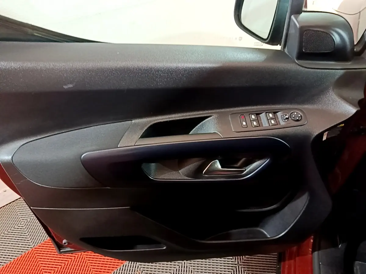 Vue rapprochée de la porte côté gauche du Peugeot Rifter marron, avec commandes électriques et poignée intégrée.