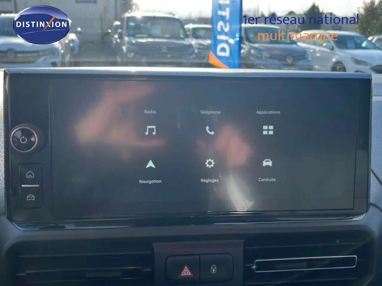 Écran tactile central du tableau de bord du Citroën Berlingo blanc, affichant les menus radio, téléphone et navigation.