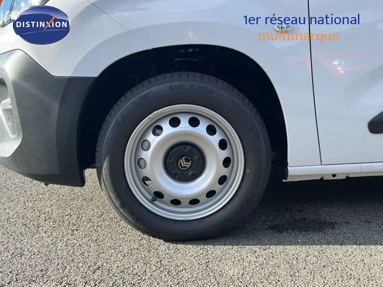 Gros plan sur la roue avant gauche d’un Citroën Berlingo blanc Icy, avec jante acier et logo Citroën central.