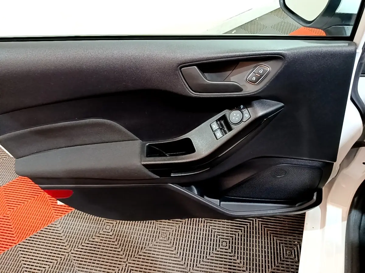 Vue intérieure côté gauche de la porte avant blanche de la Ford Fiesta 2022 avec commandes électriques et poignée noire.