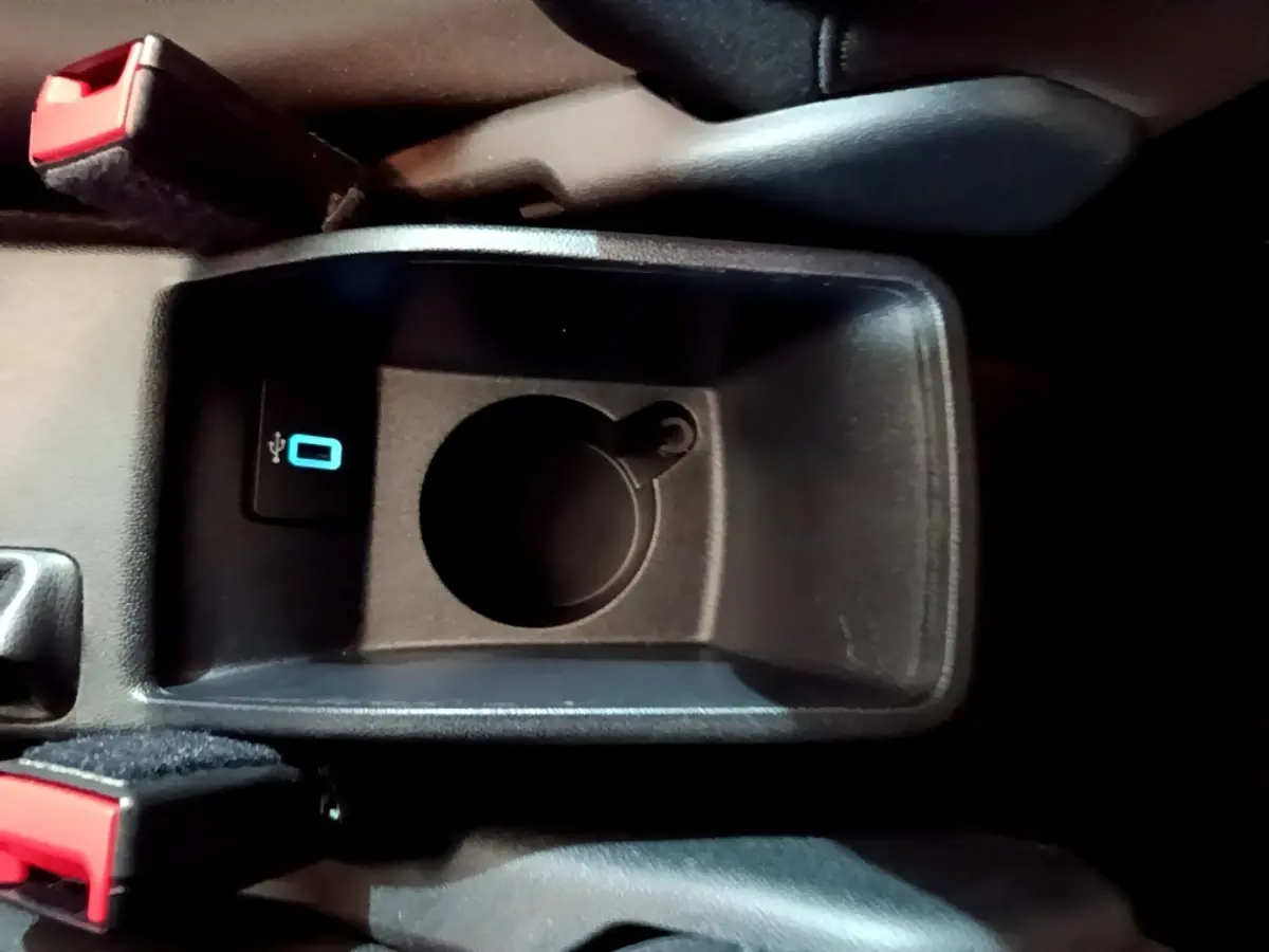 Gros plan sur la console centrale noire de la Ford Fiesta 2022 avec prise USB et emplacement porte-gobelet.