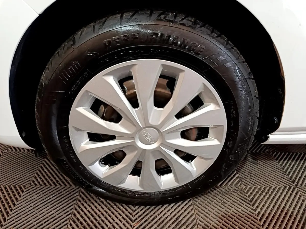 Gros plan sur la roue avant gauche blanche d'une Ford Fiesta 1.1 75ch COOL & CONNECT avec jante argentée.