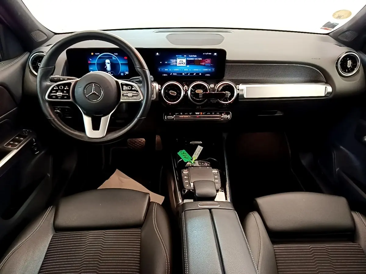 Vue intérieure avant du tableau de bord et volant cuir noir du Mercedes GLB 200 d Business Line avec écran tactile et commandes au volant.