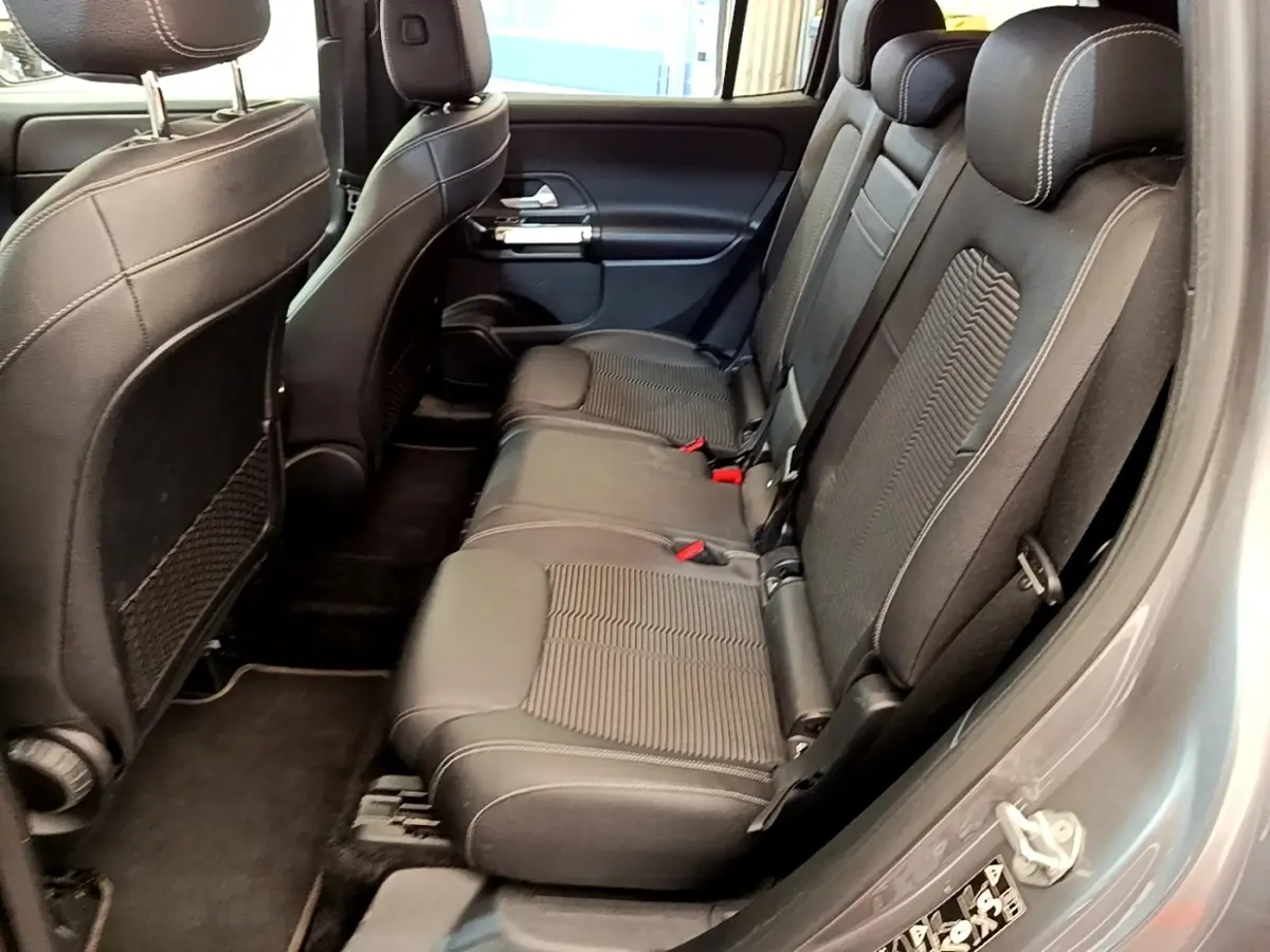 Vue côté gauche de la banquette arrière en tissu noir du Mercedes GLB 200 d Business Line gris foncé, avec appuie-têtes visibles.
