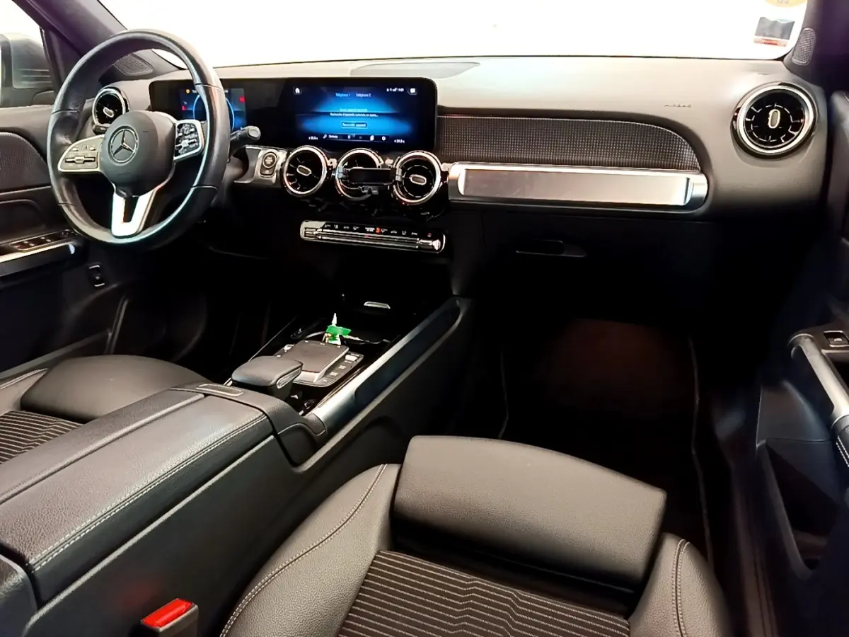 Intérieur noir du Mercedes GLB 200 d 2021 vu côté conducteur, avec tableau de bord digital et volant cuir alu.