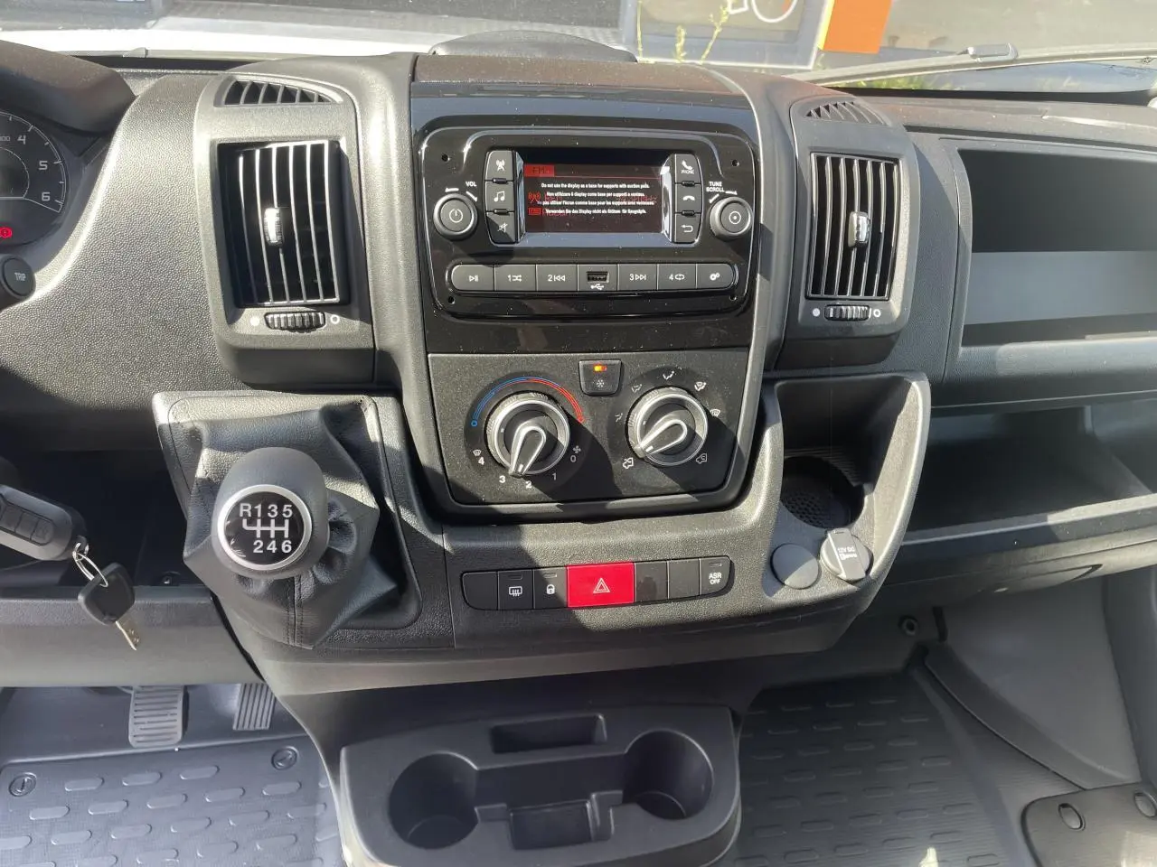 Vue rapprochée du tableau de bord noir du Citroën Jumper 2023 avec boîte manuelle et commandes de climatisation.