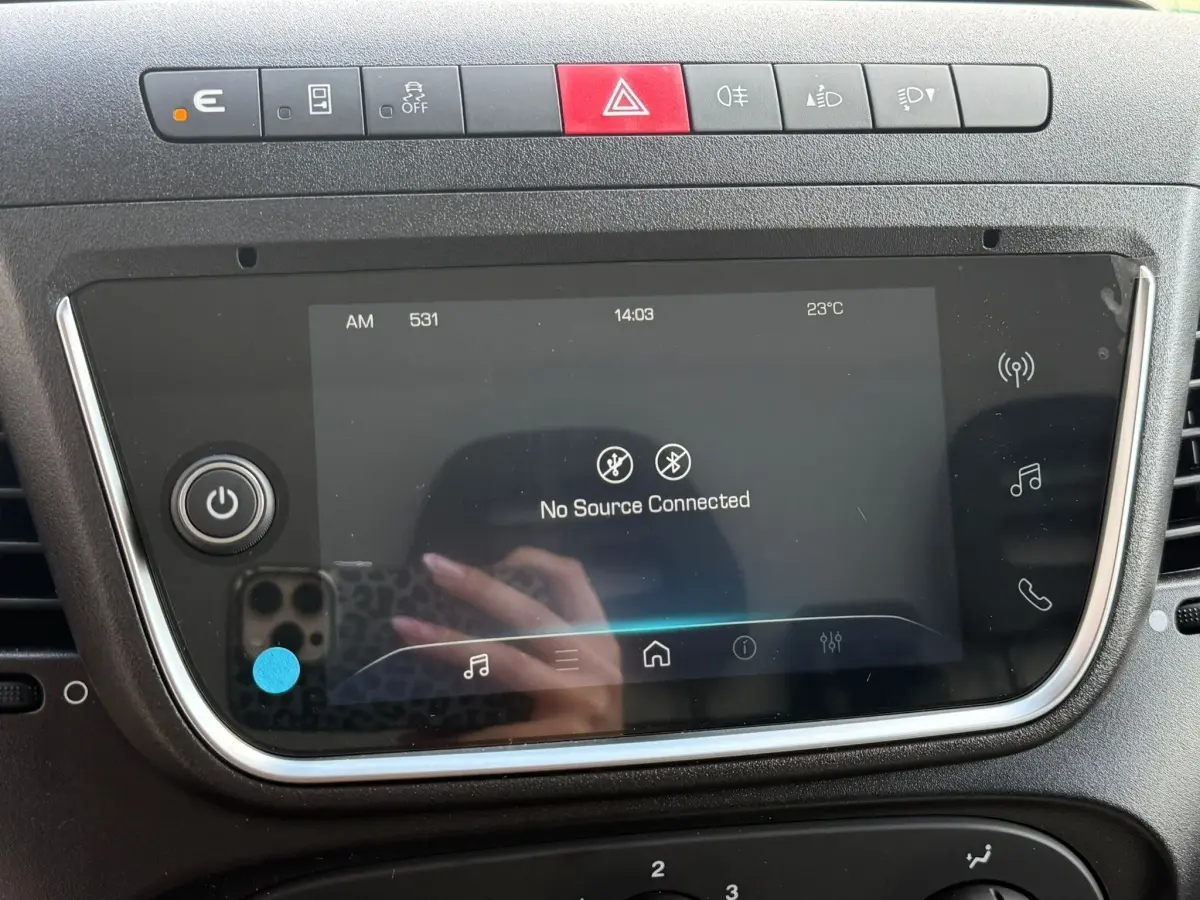 Gros plan sur l’écran tactile central et la rangée de boutons de commande du tableau de bord de l’Iveco Daily blanc.