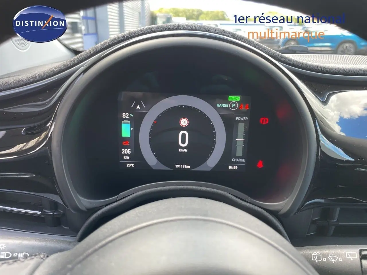 Vue rapprochée du tableau de bord numérique noir d’une Fiat 500 électrique 2023, affichant la vitesse et l’autonomie.