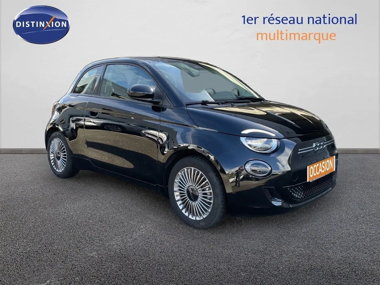 Vue 3/4 avant droite d'une Fiat 500 électrique noire Onyx avec jantes spécifiques et calandre épurée.