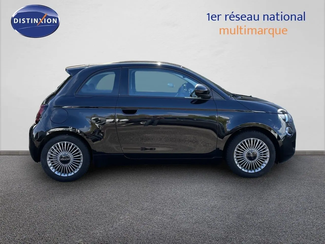 Profil droit de la Fiat 500 électrique 2023 en noir Onyx, avec jantes stylisées et lignes compactes distinctives.