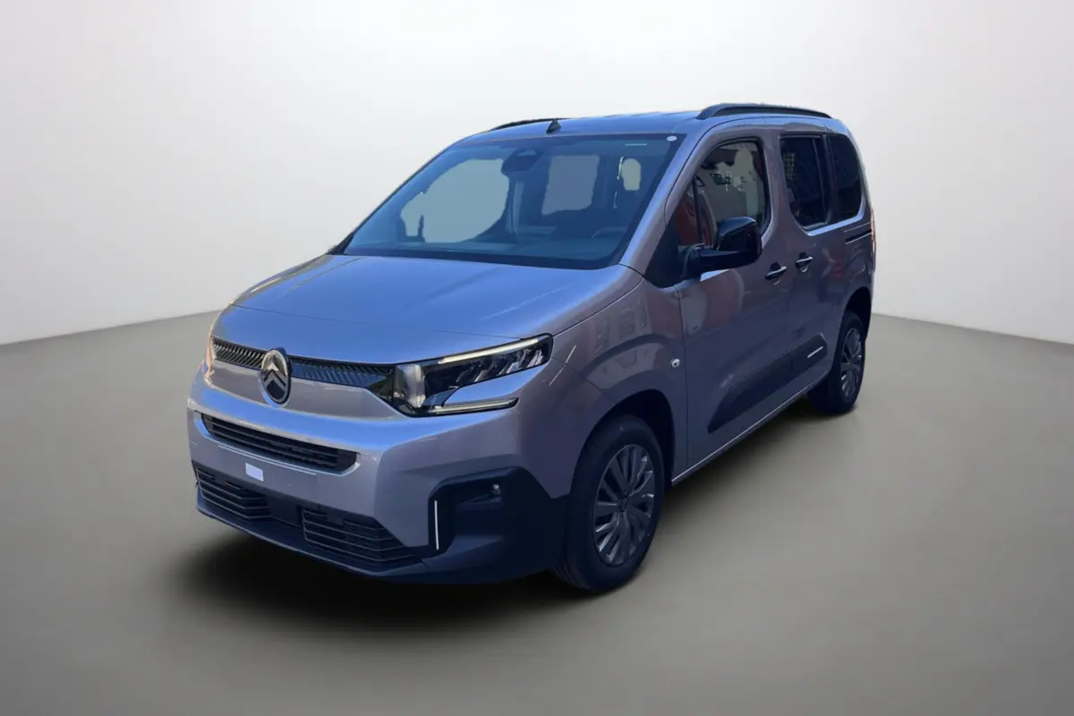 Citroën Berlingo BlueHDi 100 Feel Plus gris Artense en 3/4 avant droit avec barres de toit et vitres surteintées.