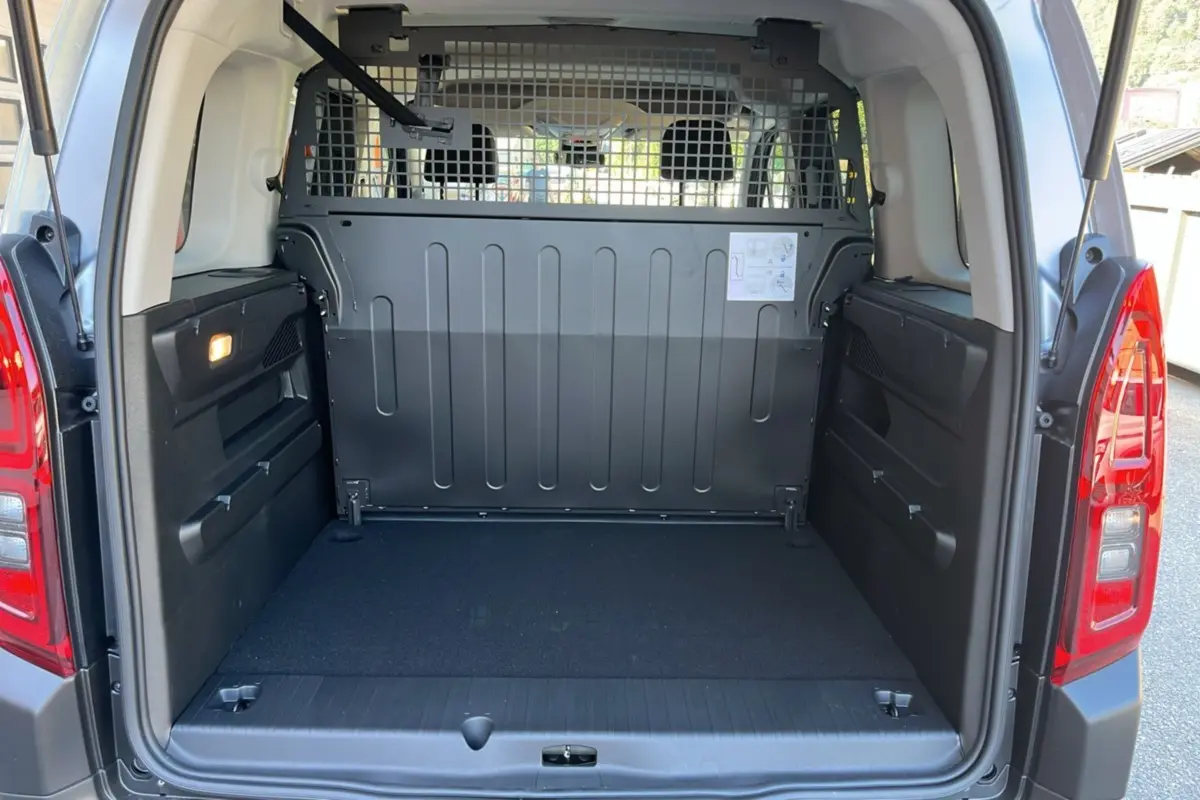 Vue arrière ouverte du Citroën Berlingo gris Artense avec cloison métallique et espace de chargement vide.