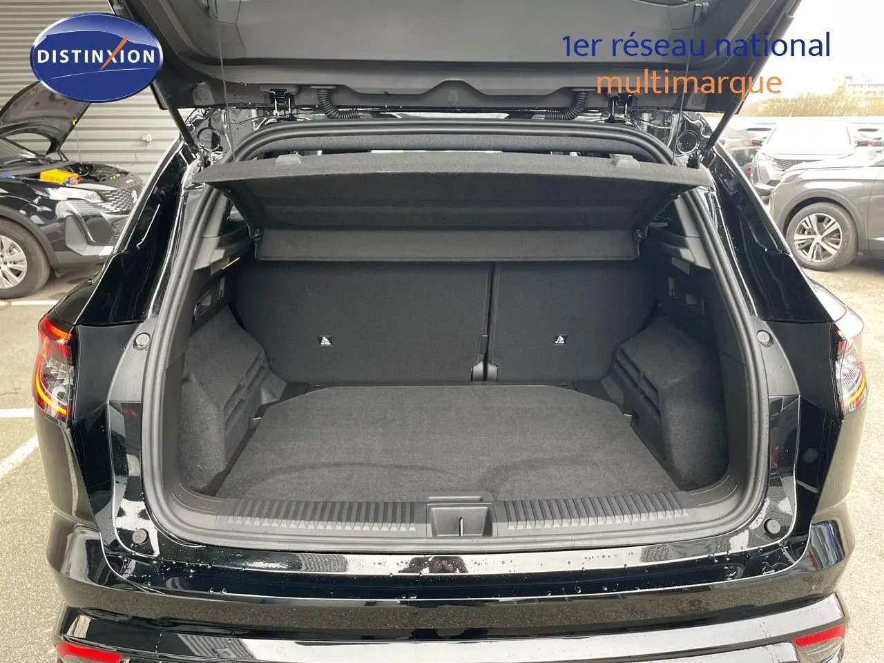 Coffre ouvert vu de l'arrière d'un Renault Austral noir étoile métal, montrant un espace de chargement spacieux et propre.