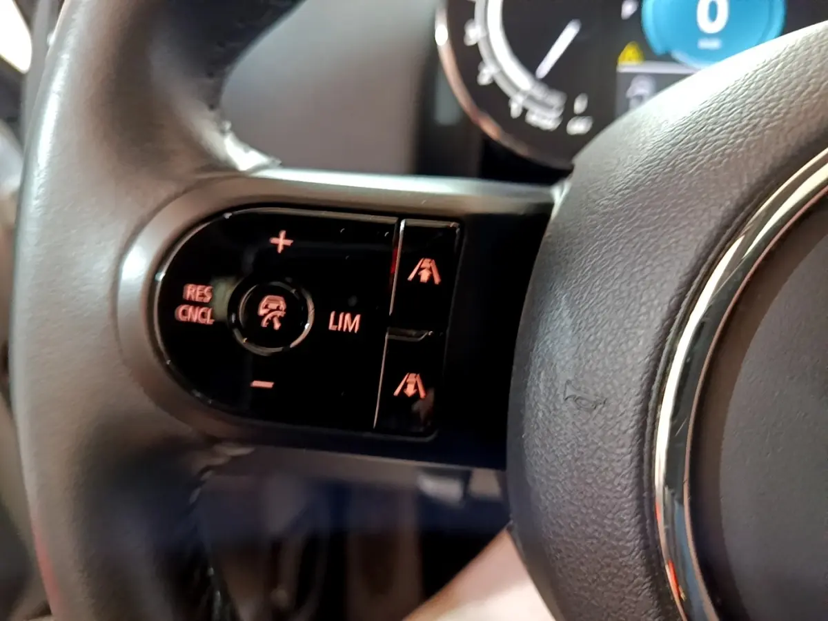 Gros plan sur les commandes de régulateur de vitesse au volant cuir du MINI Countryman gris clair 2022.