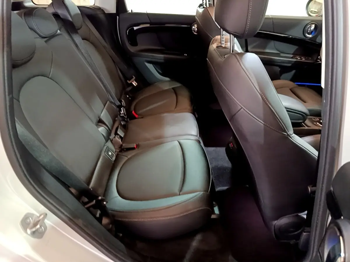 Vue intérieure côté gauche montrant la banquette arrière en cuir noir du MINI Countryman gris clair 2022.