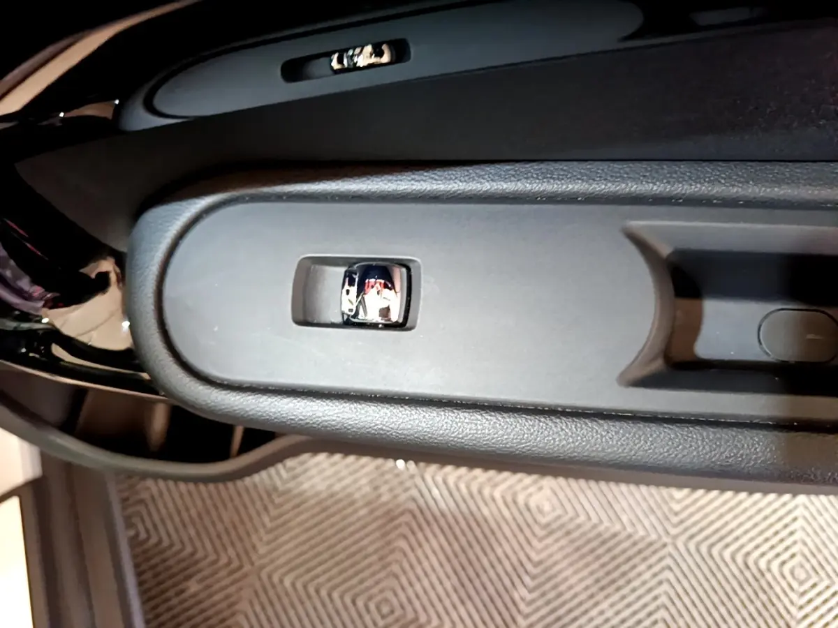 Gros plan sur la commande de lève-vitre côté porte avant d’un MINI Countryman gris clair, intérieur noir.