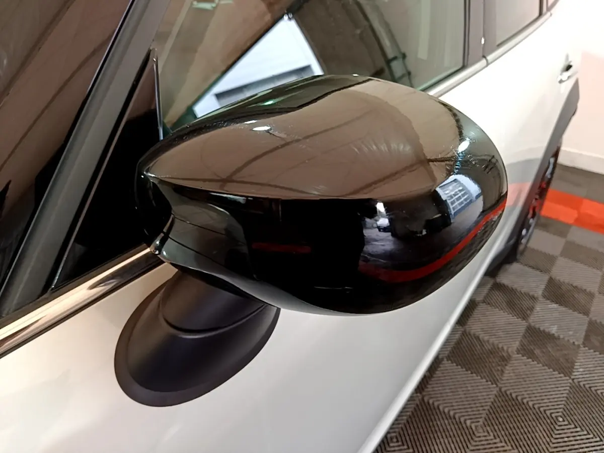 Gros plan sur le rétroviseur noir côté conducteur d'une MINI Countryman gris clair, vue latérale droite.