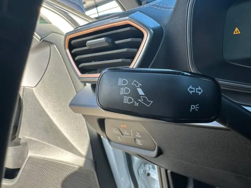 Gros plan sur le commodo gauche et la sortie d’air avec contour cuivre du tableau de bord du CUPRA Formentor blanc Nevada 2025.