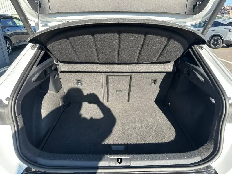 Coffre ouvert vu de l'arrière d'une CUPRA Formentor blanc Nevada métallisé, montrant l'espace de chargement vide.