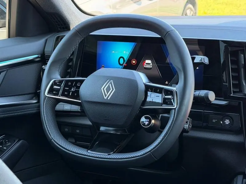 Vue rapprochée du volant multifonction noir et de l'écran digital du tableau de bord du Renault Austral 2024.