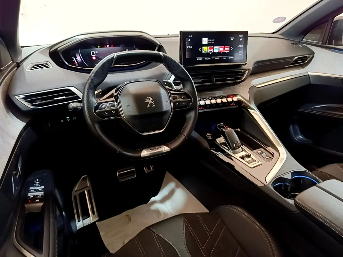 Vue intérieure avant du Peugeot 3008 GT Pack 2022, volant cuir alu, écran tactile central et console moderne noire.