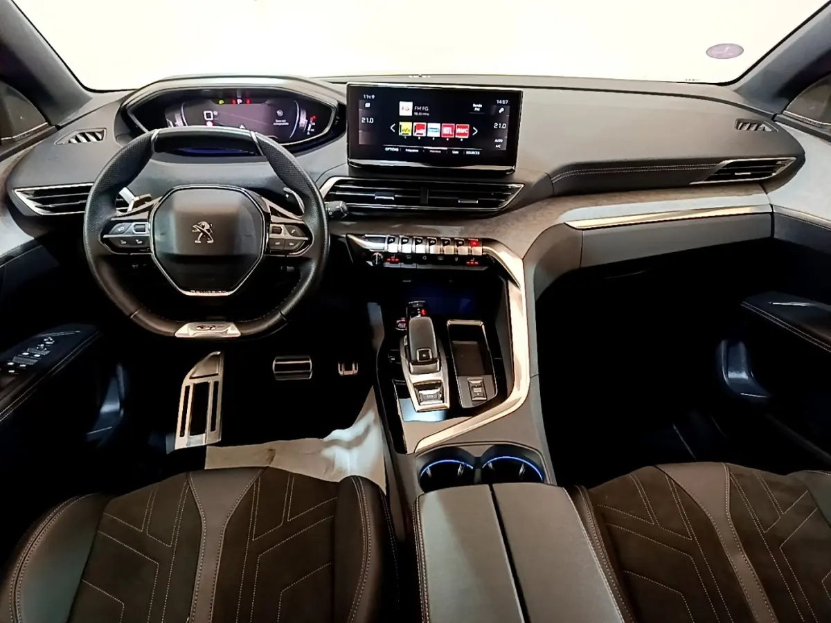 Vue intérieure avant du Peugeot 3008 GT Pack 2022, volant cuir alu multifonctions et écran tactile central noir.
