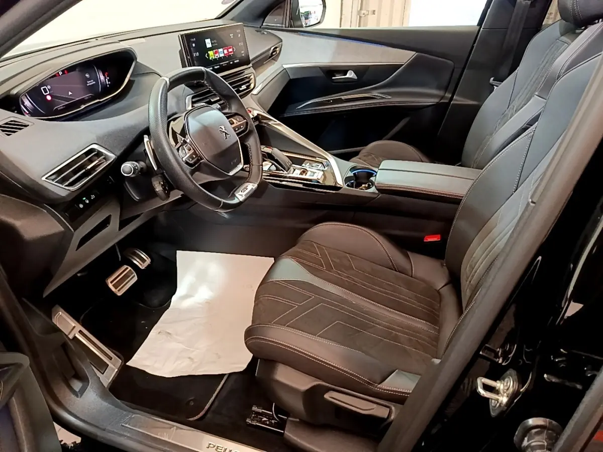 Intérieur avant droit du Peugeot 3008 GT Pack noir 2022, volant cuir alu multifonctions et tableau de bord digital.