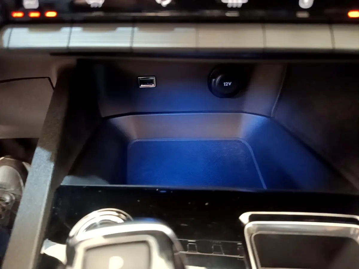 Gros plan sur la console centrale du Peugeot 3008 noir, montrant prise USB, prise 12V et partie inférieure du tableau de bord.