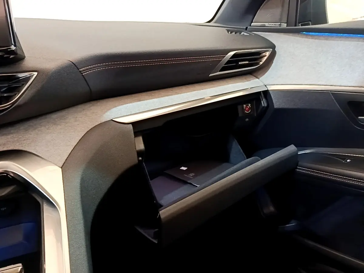 Intérieur côté passager du Peugeot 3008 GT Pack 2022, boîte à gants ouverte avec finition tissu et cuir noir.