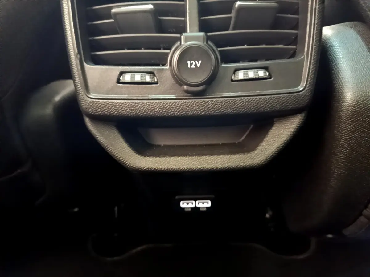 Vue rapprochée de la console arrière noire du Peugeot 3008 avec prise 12V et ports USB visibles.