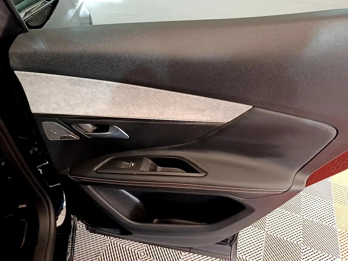Vue rapprochée de la porte avant gauche noire du Peugeot 3008 2022 avec garniture cuir et insert tissu clair.