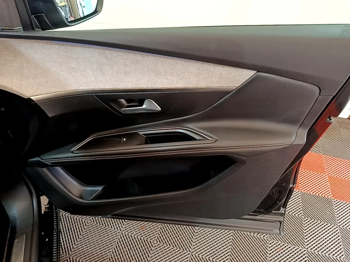 Vue intérieure côté gauche de la porte avant noire du Peugeot 3008 GT Pack 2022 avec garniture tissu et cuir.