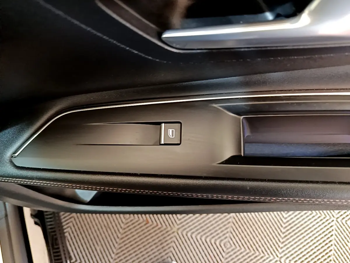 Détail de la commande de lève-vitre sur la porte côté gauche du Peugeot 3008 noir, finition GT Pack 2022.