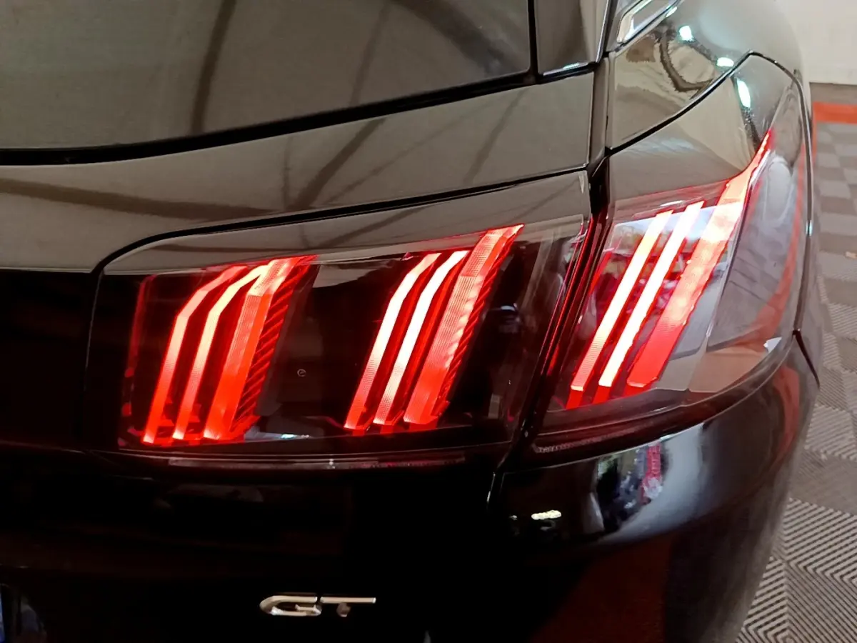 Gros plan sur le feu arrière droit rouge allumé d’un Peugeot 3008 GT Pack noir, avec logo GT visible.