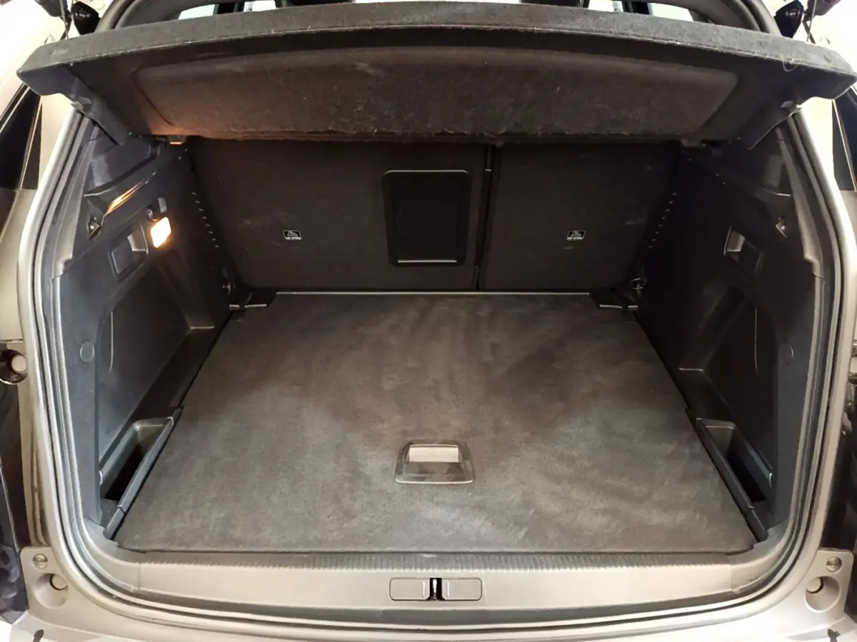 Vue arrière du coffre spacieux et propre du Peugeot 3008 noir, avec éclairage intérieur et revêtement sombre.
