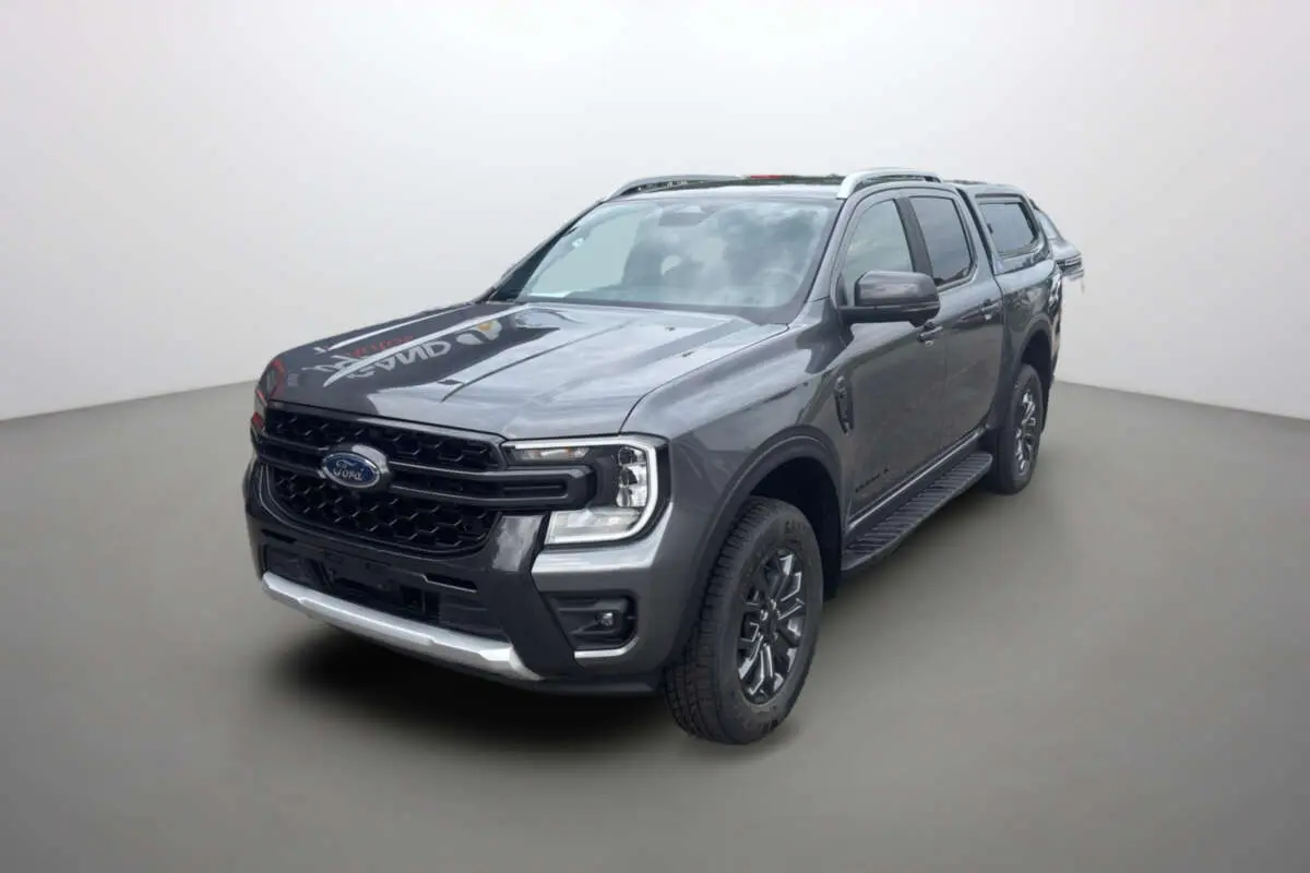 Ford Ranger V6 240 Wildtrak gris carbone en 3/4 avant droit avec hardtop et jantes alu 18 pouces visibles.