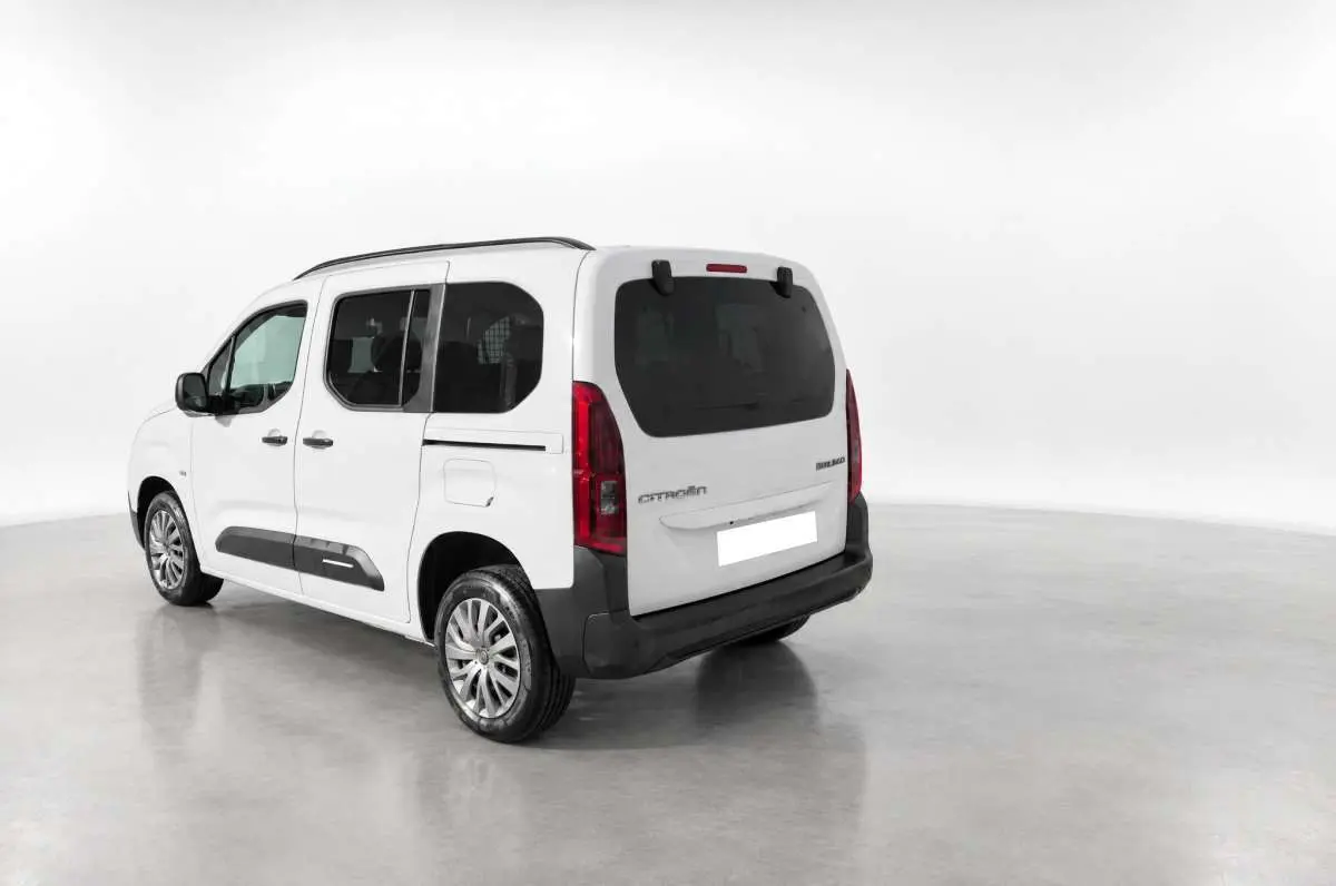Vue 3/4 arrière droite du Citroën Berlingo Kaolin white avec vitres surteintées et barres de toit visibles.