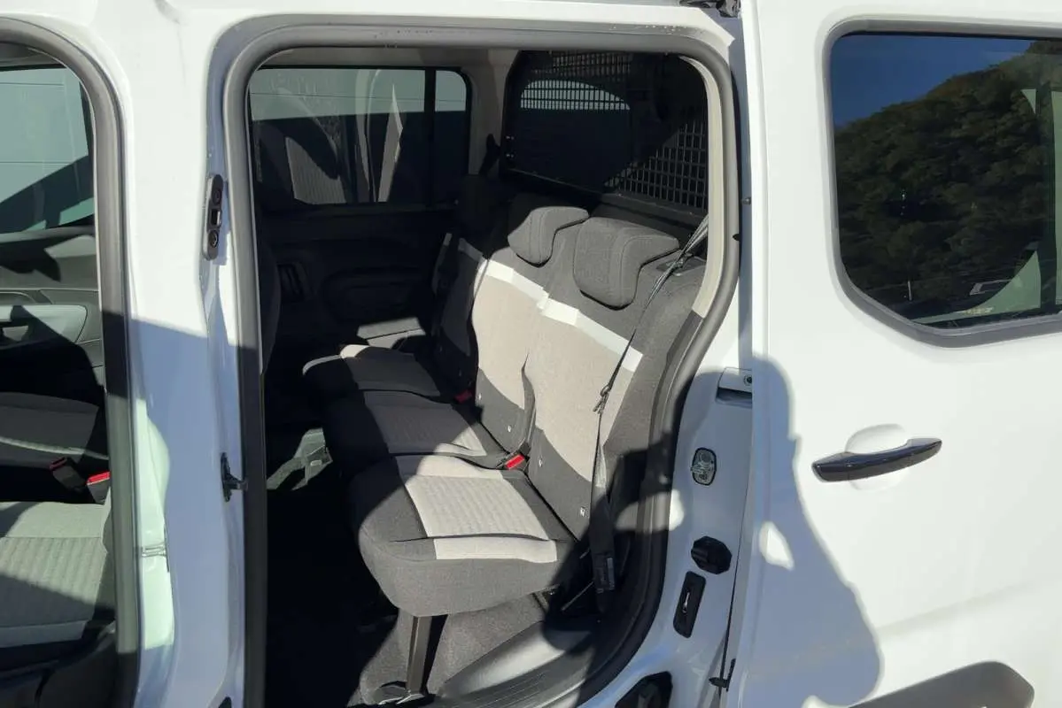 Vue intérieure côté gauche du Citroën Berlingo Kaolin white 2026, montrant les trois sièges arrière indépendants en tissu bicolore.