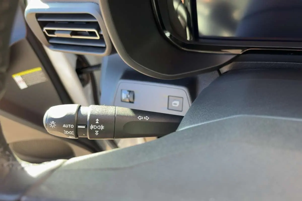 Gros plan sur la commande des feux et clignotants à gauche du volant dans l’habitacle du Citroën Berlingo Kaolin White.